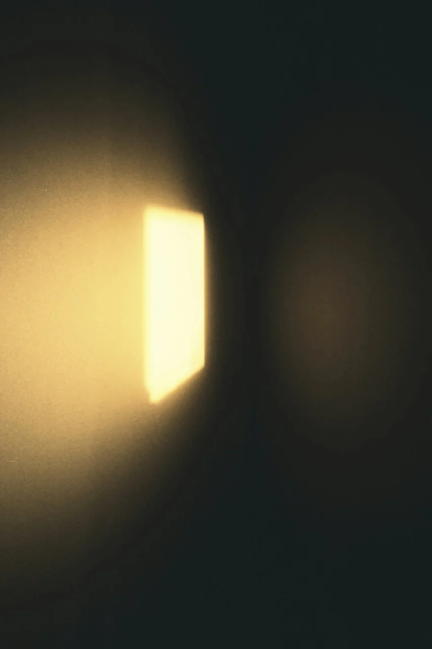 A bright rectangular patch of warm light on a dark wall