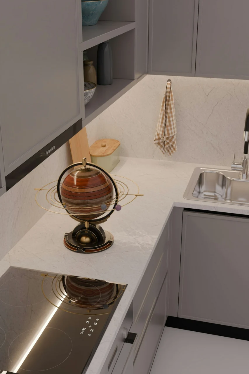 Modern kitchen countertop with a decorative globe, sink, and stovetop